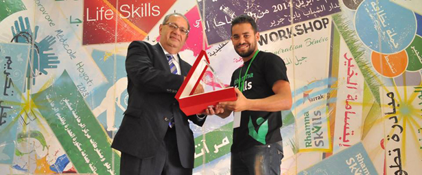 AMIDEAST President Theodore Kattouf congratulates a trainee at the Rhamna Skills Center.