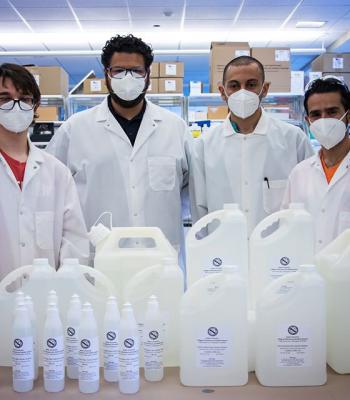 Four masked students in a lab