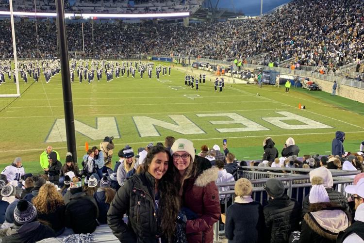 Two students in front of the endzone at a football game