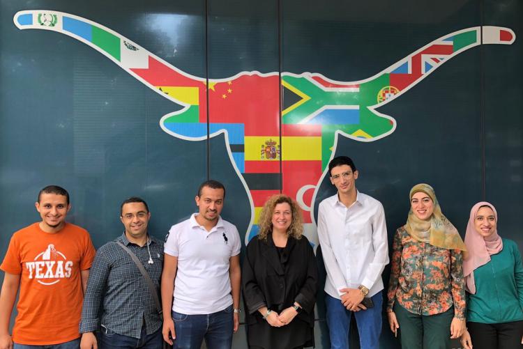 Group of graduate students in front of a Longhorns mural