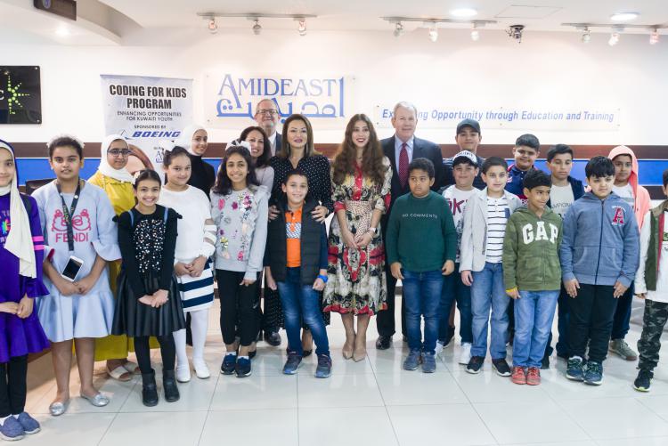 Group of younger students and teachers posing in a classroom