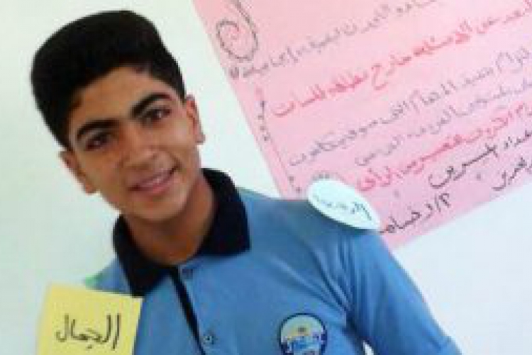 Male WISE participant smiles in front of Arabic writing