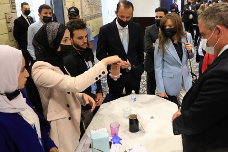 Members of the winning team demonstrate to Minister Al Nabulsi (right) how their lightweight lid fits tightly on different sizes of cups for hot and cold drinks, making it ideal for students and workers seeking to protect their clothes, belongings, and themselves from unexpected spills while on the go! 
