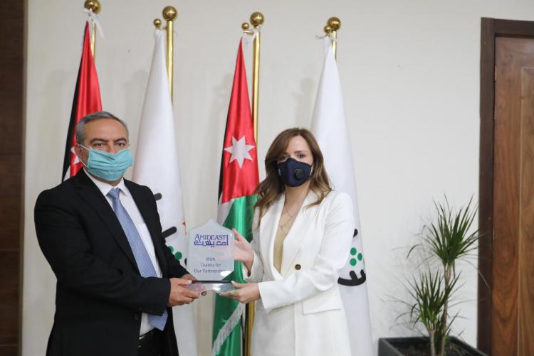 Amideast country director Nour Alrasheed holds plaque with Jordanian Youth Minister