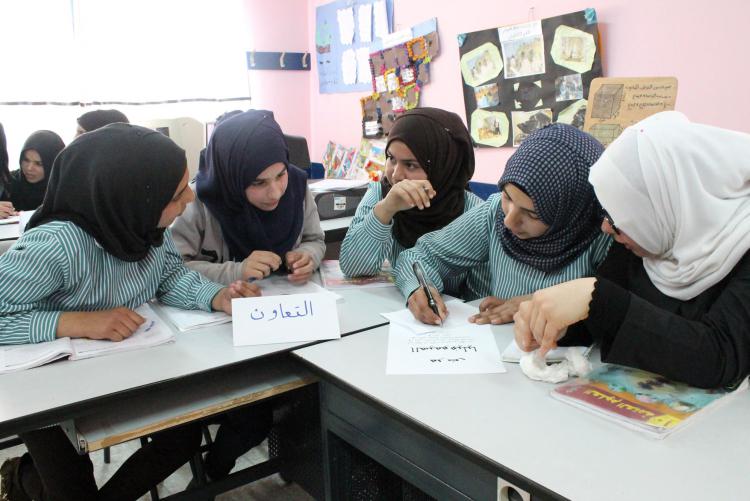 Young female students in the LTD program look at a laptop together