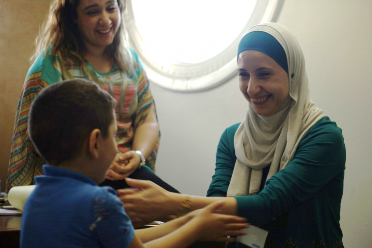 A woman in a medical setting reaches out to a young child