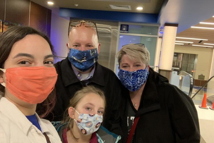 Exchange student with her host family, wearing masks