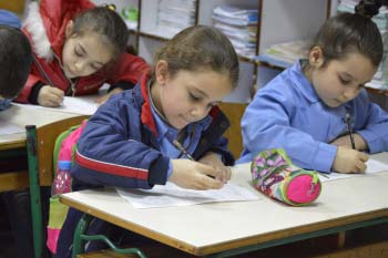 Young female students write at desks