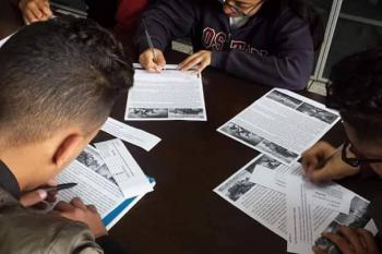 Students reading an article and writing notes