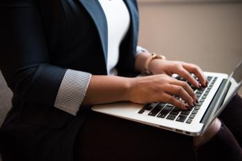 Businesswoman types on a laptop