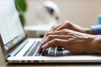 Photo of an adult typing on a laptop