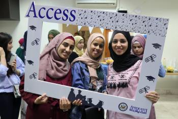 Access graduates posing in a cardboard frame