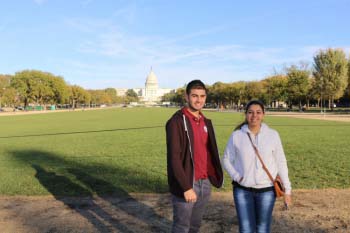 Two students stand in front of the U.S. Capitol building 
