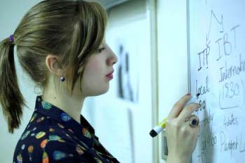 Female student writes on a whiteboard