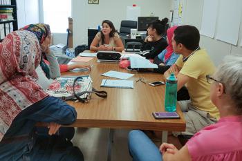 A group of scholars listens to a lecturer during their program.