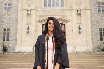 Female graduate in gown outside campus building