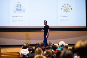 DKSSF student Ralph speaks on a stage to an audience