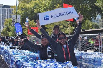 A college student holding up a banner with the Fulbright program logo
