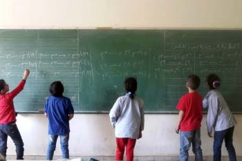 Children writing in Arabic on a blackboard as part of the Ana Iqra project