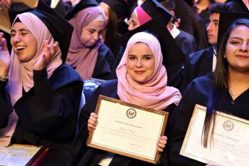 Three Access graduates holding certificates during graduation