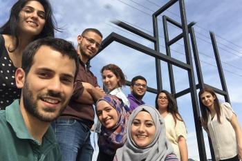 مجموعة من الطلاب في سن الكلية يبتسمون للكاميرا
