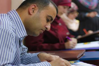 A student writes at a desk