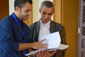 Two alumni go over paperwork at an alumni conference. 