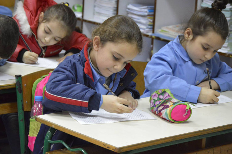 Young female students write at desks