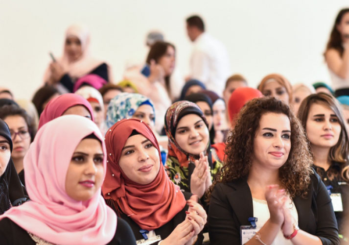Young women graduates of AMIDEAST's Skills for Success program in Lebanon sit in a large room for the ceremony