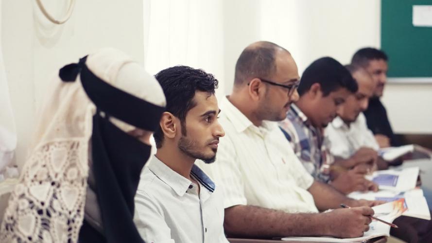 Yemeni high school students listening to an educational adviser in a classroom