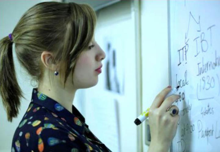 Female student writes on a whiteboard