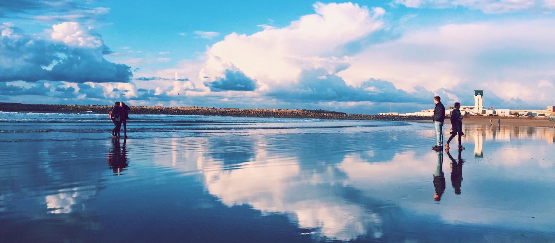 Panorama view of the beach in Rabat, Morocco, with a water reflection of the sky.