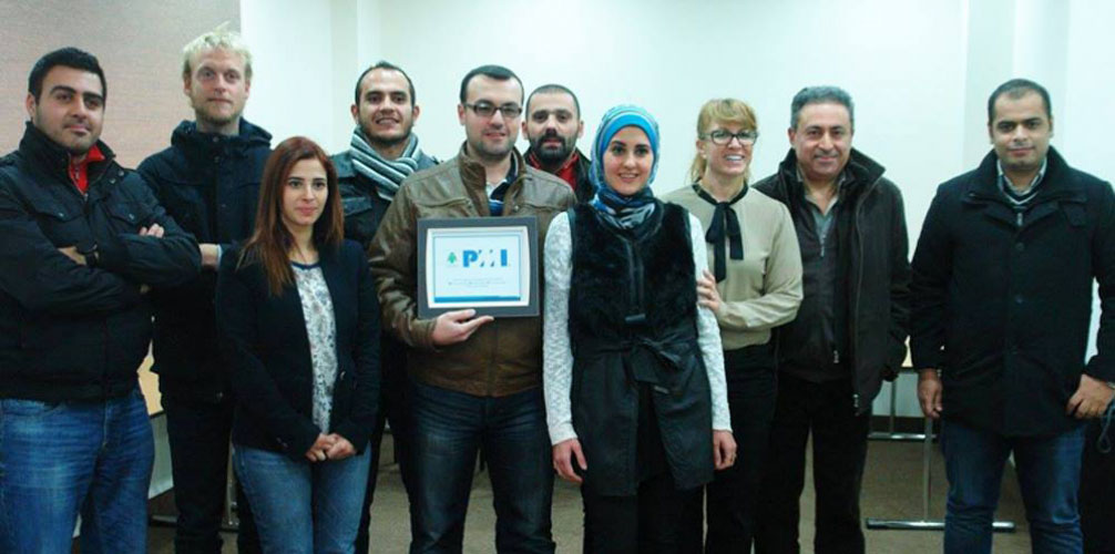 Group of students pose while one holds up a certificate