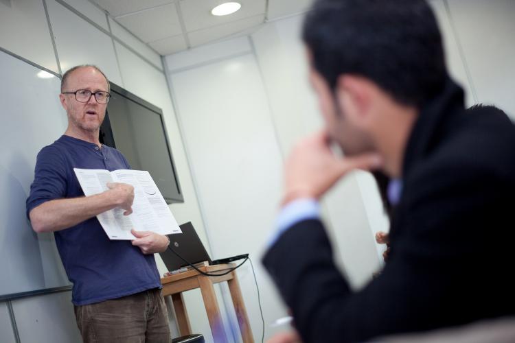 A teacher goes over Fulbright with a seated prospective Fulbrighter