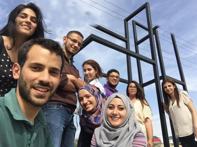 A group of college aged students smile at the camera