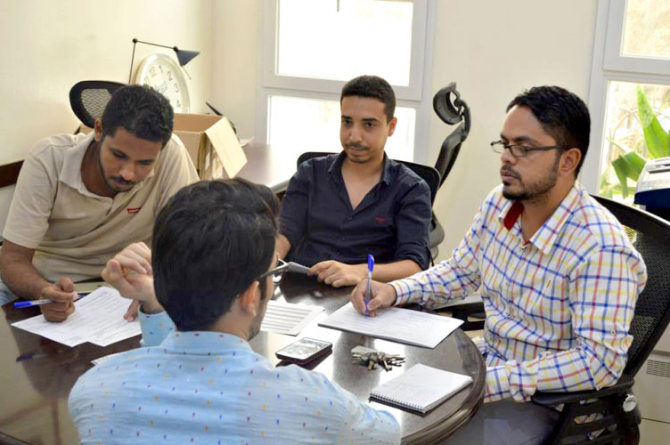 Group of young professional men work together at a table