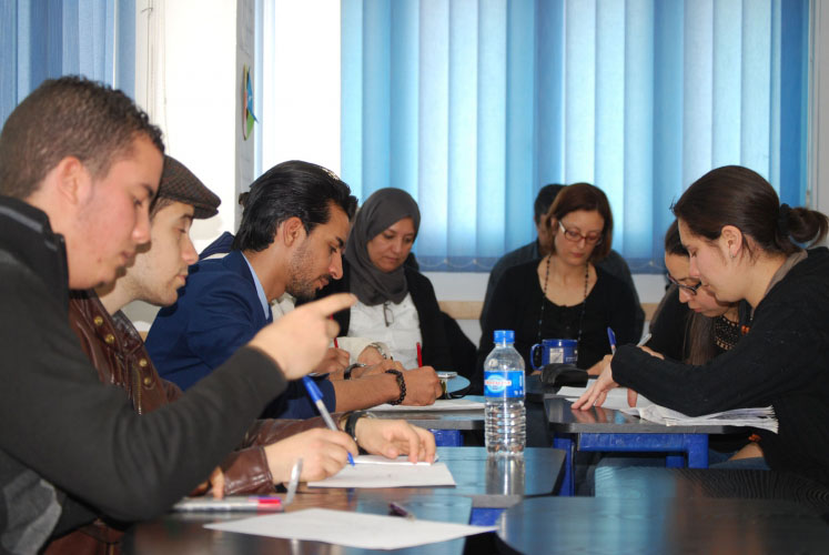 A group of workers studiously focus on their English program