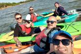 A group of Fulbright Scholars in kayaks, smiling.