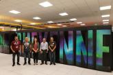 A group of Fulbright scholars in front of a large decorated wall.