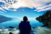 student kayaking on a lake in mountains