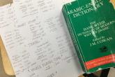 An Arabic to English Dictionary next to a list of new vocabulary