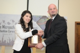 Country director presenting plaque to an Access essay winner
