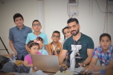 A man shows a group of young students how to code