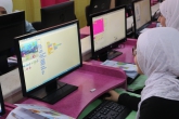 فتاة صغيرة تستخدم الحاسوب لعمل رموز