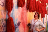 Student standing in Marrakech next to dyed fabric in Morocco