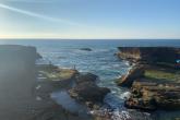 The sun lights up ocean as it comes towards shore among the cliffs in Rabat.