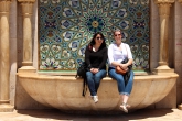 Two students sit on the edge of the decorative fountain at the Hassan II Mosque in Casablanca