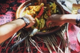 Hands taking traditional Moroccan food from a center bowl