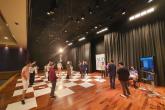 Students play a game of human chess on a stage at AUD