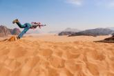 Spring 2019 student jumps from a dune in Wadi Rum.